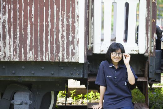 Girls wearing glasses Smiling happily Park in the shade and enjoy.