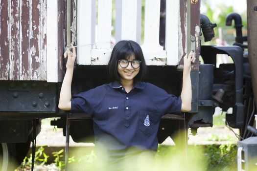 Girls wearing glasses Smiling happily Park in the shade and enjoy.