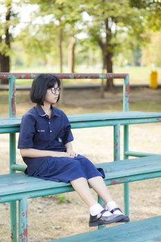 Girl wearing glasses sitting on the bench. Emotional loneliness and isolation alone. Sitting in the park