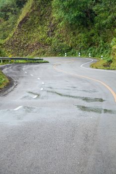 Curvy road. The road is crooked, turn on the hill. Near cliffs. The ascent to the summit of mountain