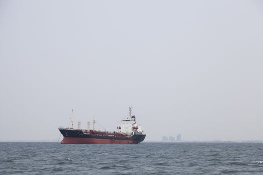 Large cargo ship Boats moored in the sea to make sense compared to the coast.