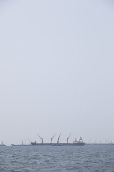 Large cargo ship Boats moored in the sea to make sense compared to the coast.