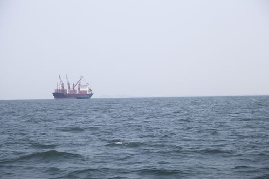 Large cargo ship Boats moored in the sea to make sense compared to the coast.