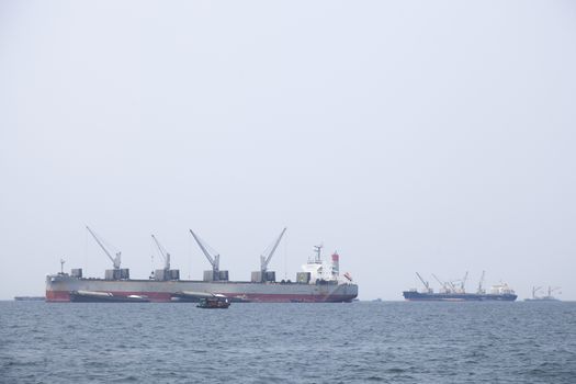 Large cargo ship Boats moored in the sea to make sense compared to the coast.