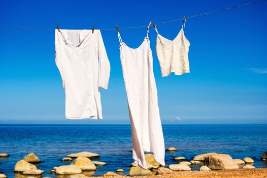 White shirts hanging on a rope on the seashore