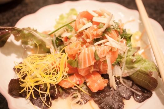 Salmon spicy salad on white plate, stock photo