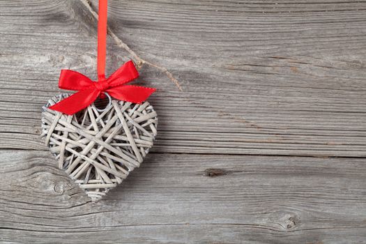 Heart shaped decoration made of wood, over wooden background