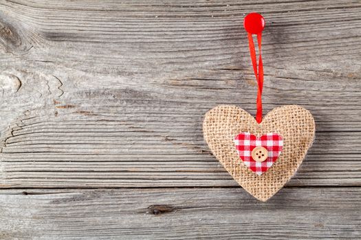 Heart shaped decoration made of wood, over wooden background