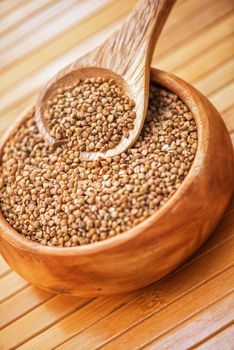buckwheat at wooden plate on wooden background