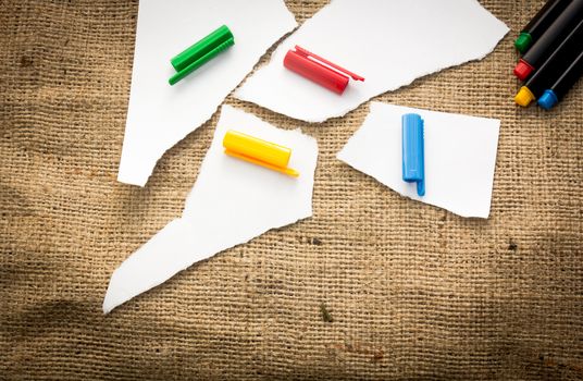 Four white paper pieces decorated with four different colours