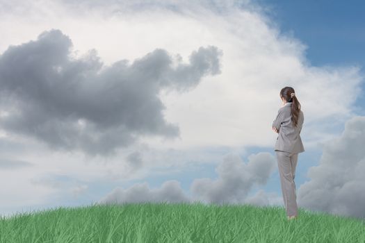 Asian business woman standing on grassland and thinking with copyspace on heaven.