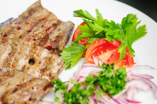 fried beef or pork liver with fresh vegetable salad served on plate
