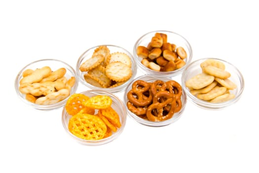 Bowls of pretzels on glass on white background