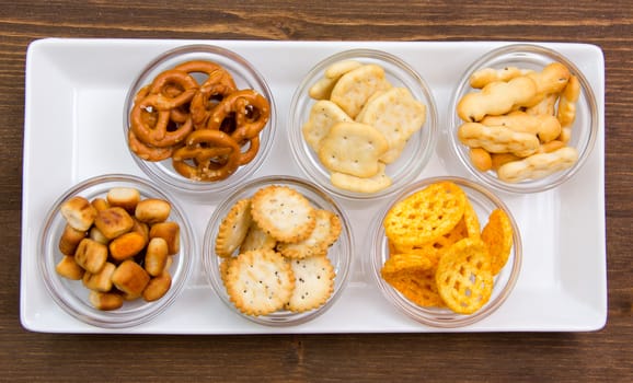 Bowls of pretzels on tray on wooden table top views