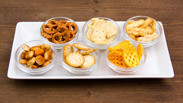 Bowls of pretzels on tray on wooden table