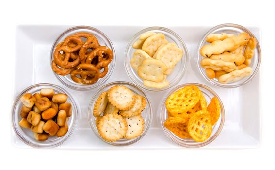 Pretzels in bowls on tray on white background seen from above