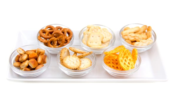 Pretzels in bowls on tray on white background