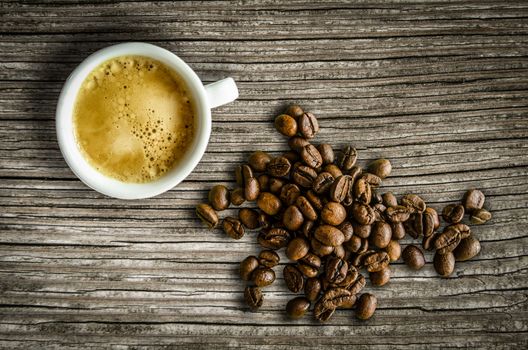 Retro Style Image Of A Cup Of Espresso Coffee With Some Organic Coffee Beans On A Rustic Table