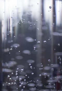 Glass of sparkling water soft drink closeup on carbon dioxide gas bubbles.