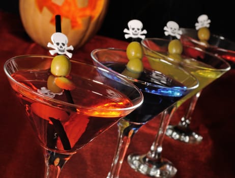 A variety of drinks in a glass with olives on a cocktail straw