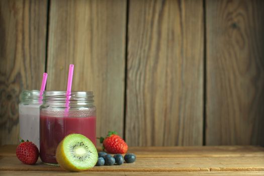 Fruit smoothies on a wooden table with space for text 