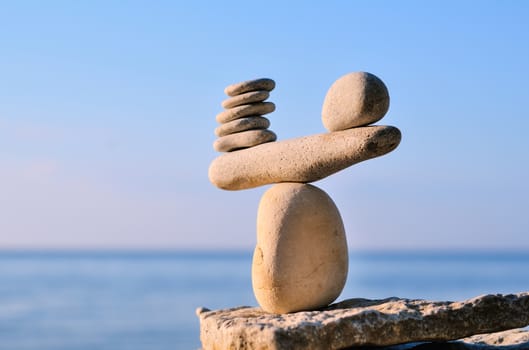 Balancing of white pebbles each other on the seacoast