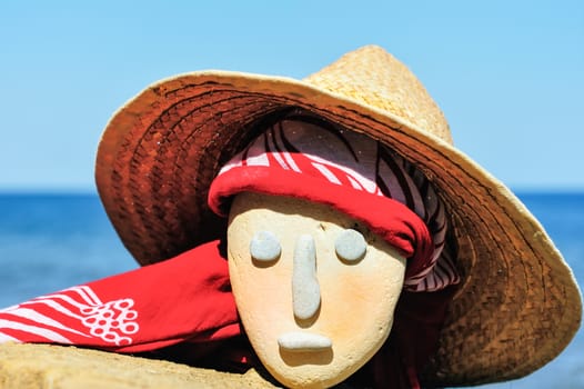 Stone head with a wicker hat and bandana