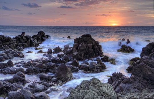 Sunrise over the Minamurra rugged, craggy volcanic rocks and ocean flows at low tide
