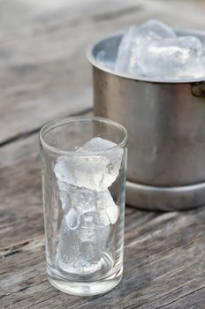 Glass with ice cubes and Ice bucket filled with ice cubes