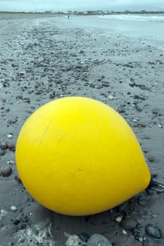 giant yellow buoy on a beach in the wild atlantic way