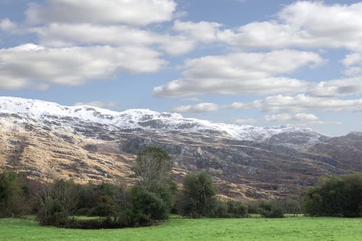 rocky mountain and fields countryside snow scene in irish speaking area of county Kerry Ireland with copyspace