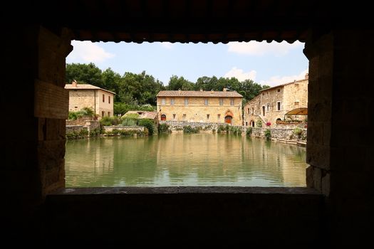Old thermal baths in the main piazza of medieval village Bagno Vignoni, Tuscany, Italy 