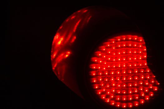 Traffic red stop light photo at night on black background.