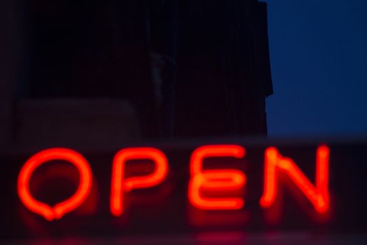 Neon open sign at night in street photo.