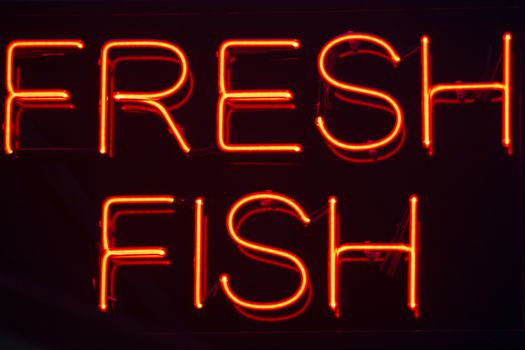 Fresh fish  neon sign at night in street photo.