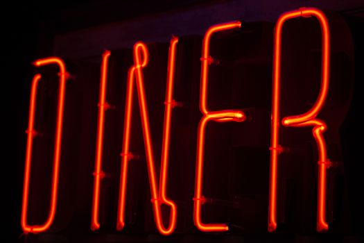 Diner neon sign at night in street photo.