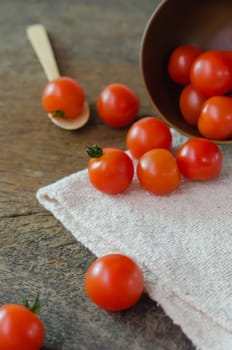 Red cherry tomatoes  on a textured  wooden background
