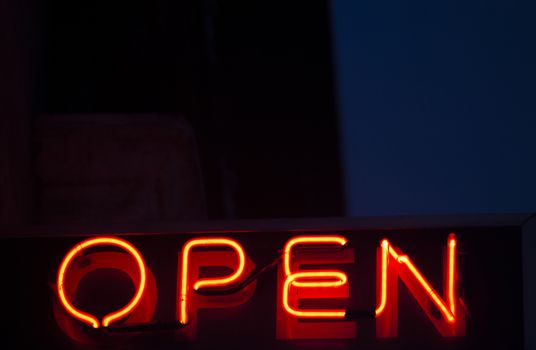 Neon open sign at night in street photo.