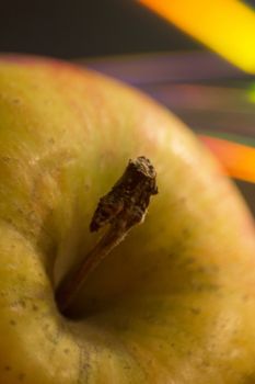 Red and green apples close-up photo with colorful background.