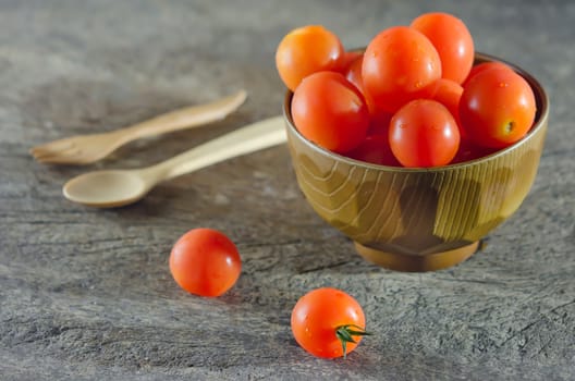 Red cherry tomatoes  on a textured  wooden background