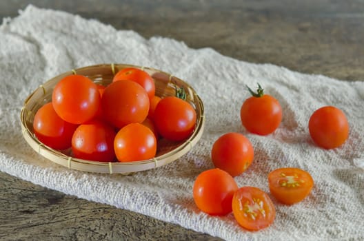 Red cherry tomatoes  on a textured  wooden background