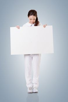 Smiling Asian nurse holding blank board, woman portrait isolated.