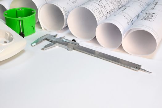 Drawing rolls, wall socket, socket box, sliding calipers on white surface