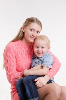 On the lap of a young beautiful girl sits her three year old son