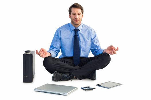 Man sitting in lotus pose with laptop, tablet and suitcase on white background