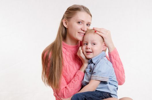 On the lap of a young beautiful girl sits her three year old son