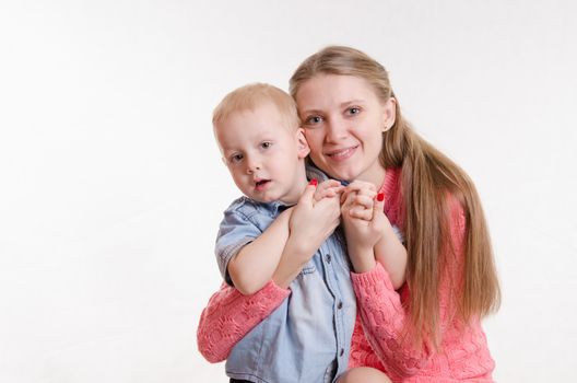 Young beautiful girl sitting on a chair with a three year old son