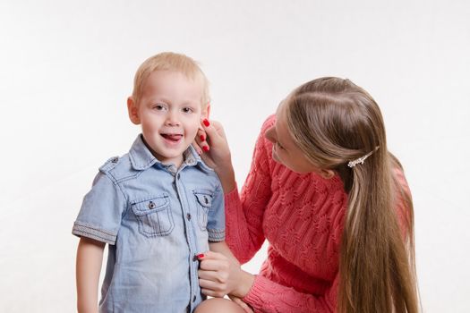 Young beautiful girl sitting on a chair with a three year old son