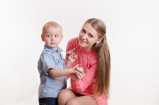 Young beautiful girl sitting on a chair with a three year old son