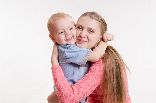On the lap of a young beautiful girl sits her three year old son